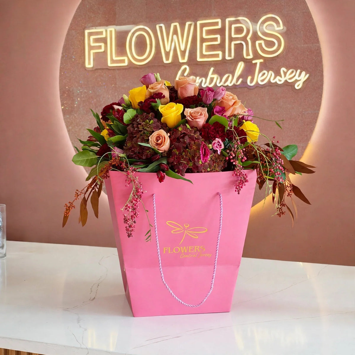 Fall flower arrangement in a pink FLOWERS Central Jersey bag